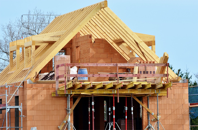 Nuova costruzione di una casa: muri in mattoni e struttura del tetto in legno in costruzione. Nuova costruzione di una casa: muri in mattoni e struttura del tetto in legno in costruzione.